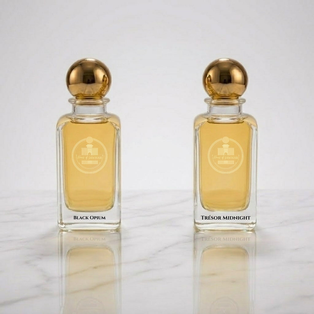 Black Opium and Trésor Midnight inspired perfume bottles by Haus Of Jawhar displayed on a reflective marble surface.