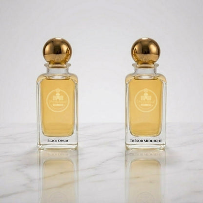 Black Opium and Trésor Midnight inspired perfume bottles by Haus Of Jawhar displayed on a reflective marble surface.
